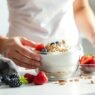 Eine Person bereitet ein gesundes Frühstück zum Abnehmen mit frischen Zutaten zu